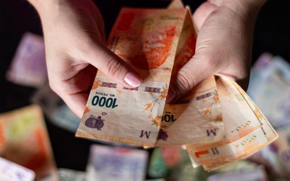 Kilka banknotów peso kubańskiego rozłożonych na stole obok portfela podróżnego